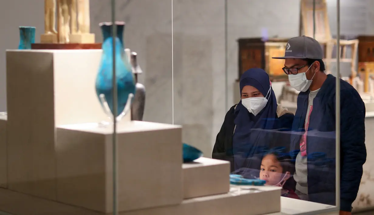 Pengunjung melihat artefak yang dipamerkan di Museum Nasional Peradaban Mesir (NMEC), Distrik Fustat, Kairo Lama, Mesir, 4 April 2021. Museum Nasional Peradaban Mesir kembali dibuka sehari setelah upacara Parade Emas Firaun. (Mahmoud KHALED/AFP)