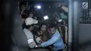 Terdakwa korupsi proyek e-KTP, Setya Novanto (tengah) dikawal ketat saat naik mobil tahanan KPK usai menjalani sidang putusan di Pengadilan Tipikor, Jakarta, Selasa (24/4). Setya Novanto divonis 15 tahun penjara. (Liputan6.com/Helmi Fithriansyah)