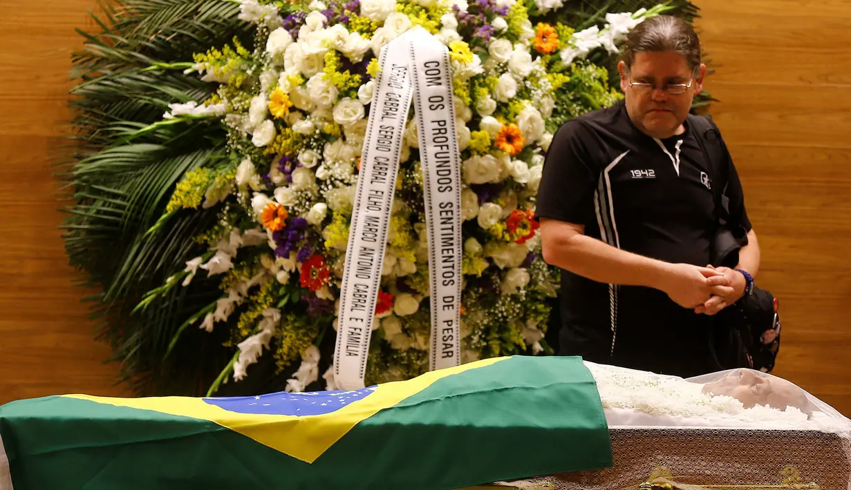 Seorang pelayat yang memberi penghormatan didekat jenazah mantan pemain sepak bola Brasil, Carlos Alberto yang sedang disemayamkan di di Konfederasi Sepakbola Brasil (CBF) di Rio de Janeiro, Brasil (25/10). (Reuters/ Ricardo Moraes)