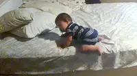 Lihatlah, bagaimana bayi laki-laki ini berusaha untuk turun dari ranjang dengan cara yang aman dan cerdas.