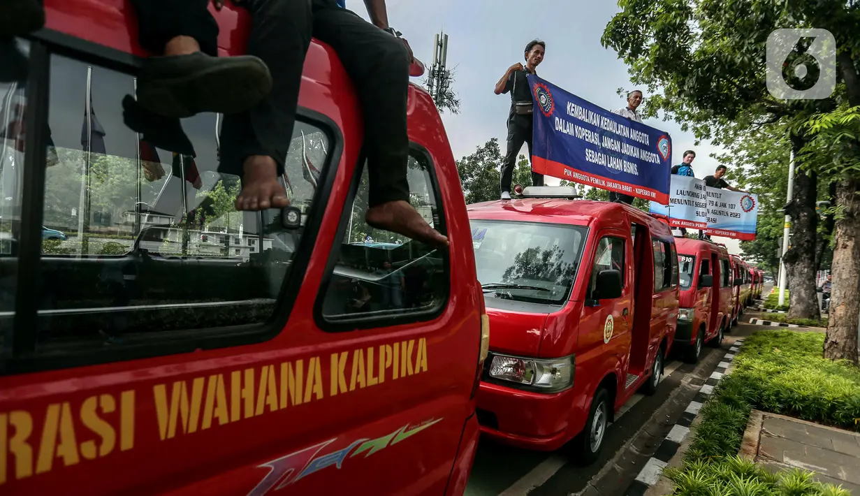 Sejumlah sopir angkot Koperasi Wahana Kalpika (KWK) membentangkan spanduk saat menggelar aksi di Balai Kota DKI Jakarta, Rabu (2/8/2023). (Liputan6.com/Faizal Fanani)