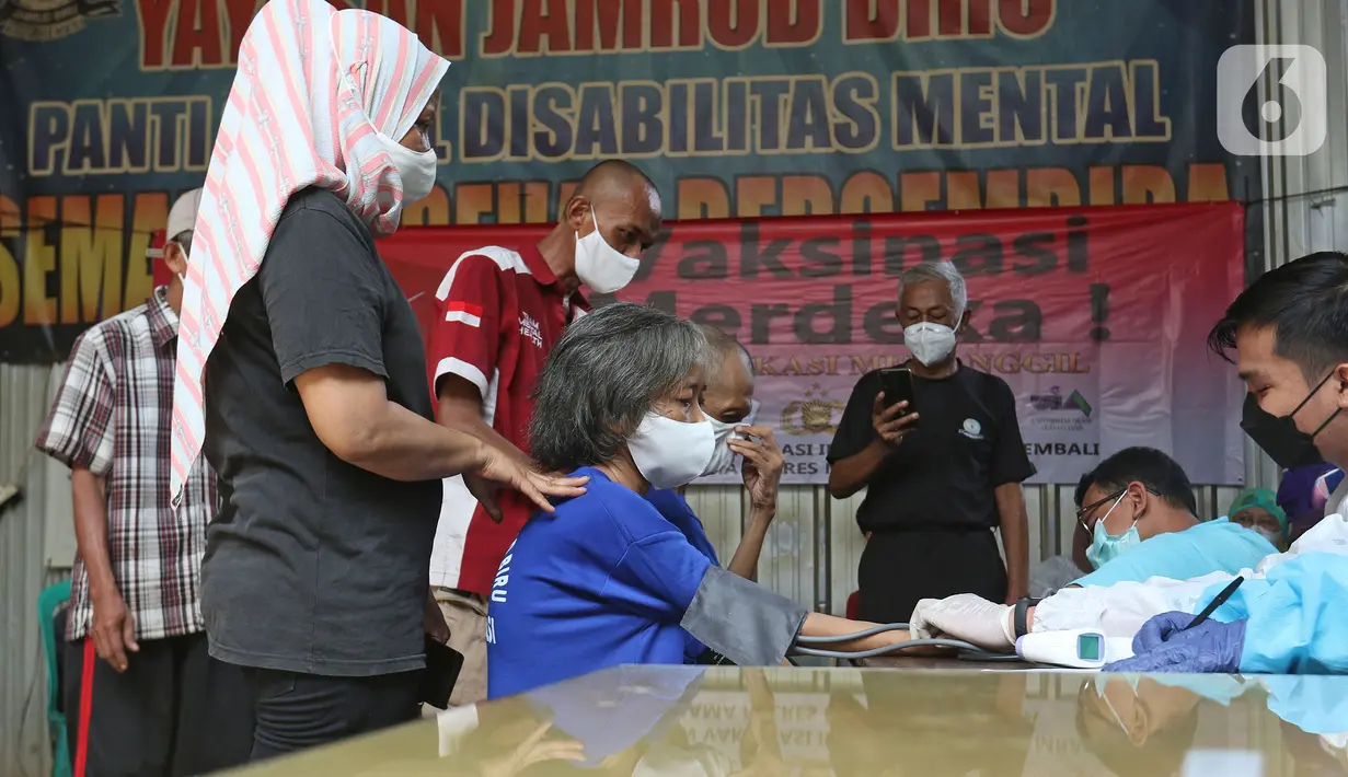Petugas mengecek kesehatan pasien ODGJ saat mengikuti vaksinasi COVID-19 di Bekasi, Jawa Barat, Rabu (4/8/2021). Sebanyak 70 pasien ODGJ mengikuti kegiatan vaksinasi merdeka guna mencegah penyebaran wabah COVID-19. (Liputan6.com/Herman Zakharia)