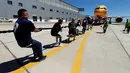 Anggota tim sekuat-tenaga untuk menarik pesawat DHL Boeing 757 sejauh 20 meter di Safi Aviation Park, Malta pada 1 Mei 2019. Kegiatan tarik pesawat tersebut merupakan rangkaian dalam rangka untuk penggalangan dana amal. (REUTERS/Darrin Zammit Lupi)