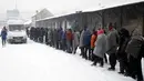 Para imigran terpaksa mengandalkan makanan dari bantuan dan tempat tinggal seadanya untuk bertahan hidup di tengah musim dingin di Belgrade, Serbia (11/1). (AP Photo/Darko Vojinovic)