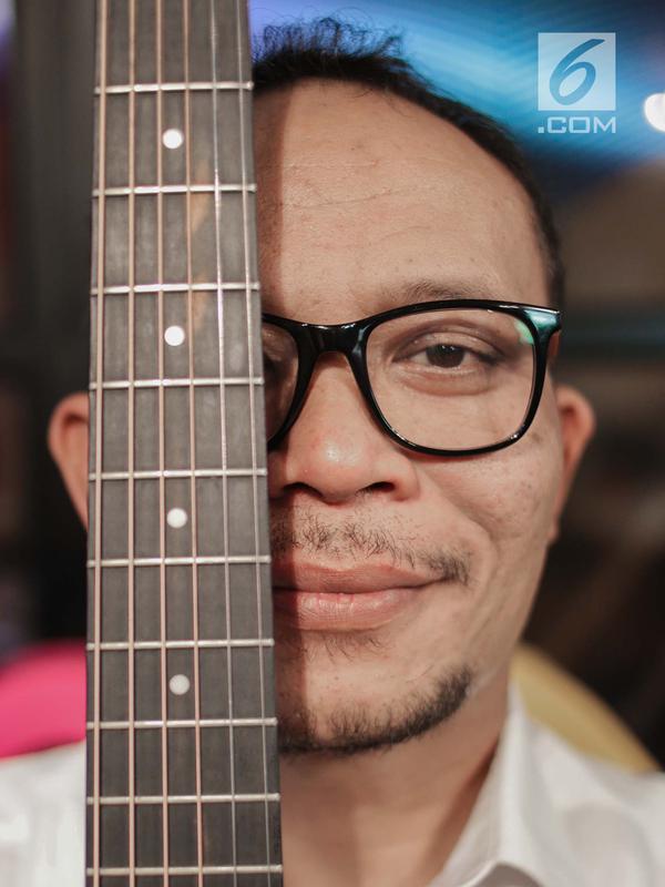 Menteri Ketenagakerjaan M. Hanif Dhakiri berpose dengan gitar sebelum tampil menjadi bintang tamu dalam acara KLY Lounge di Gedung KLY, Gondangdia, Jakarta, Jumat (5/10). (Liputan6.com/Faizal Fanani)