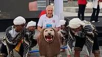Pelatih Port FC, Alexandre Gama, naik sisingaan di halaman Gedung Sate, Bandung, Jawa Barat, di sela-sela konferensi pers Piala Presiden 2025, Jumat (11/7/2025). (Bola.com/Muhammad Faqih)