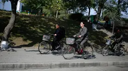 Sejumlah pria Korea Utara mengendarai sepeda mereka di Pyongyang, Korea Utara, (21/10).  (AP Photo / Dita Alangkara)