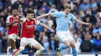 Gelandang Manchester City, Kevin de Bruyne, mencoba melepaskan diri dari kawalan&nbsp;gelandang Arsenal, Declan Rice, saat bertanding pada pekan 30 Liga Inggris 2023/2024 di Stadion Etihad, Minggu (31/3/2024) malam WIB.&nbsp;(AP Photo/Dave Thompson)