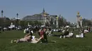 Orang-orang bersantai saat menikmati matahari di Esplanades des Invalides di Paris, Selasa (30/3/2021). Cuaca panas diperkirakan akan berlangsung selama beberapa hari di seluruh negeri. (AP Photo/Christophe Ena)