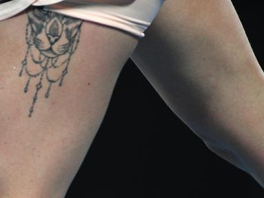 Detail tato bergambar jaguar terlihat di paha kiri petenis Ukraina, Elina Svitolina saat bertanding pada grand slam Australia Terbuka 2018 di Melbourne, Senin (22/1). Tato tersebut pertama kali dikenalkan di ajang China Open 2017 lalu. (SAEED KHAN/AFP)
