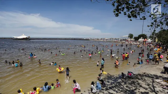 Libur Natal, Warga Menikmati Liburan Murah Meriah di Pantai Ancol