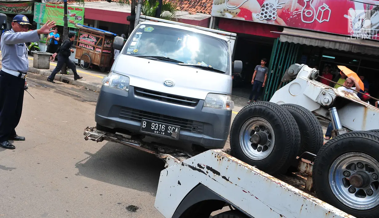 Petugas Dinas Perhubungan DKI Jakarta menderek mobil yang parkir di bahu jalan di kawasan Jatinegara, Jakarta, Senin (2/10). Razia parkir liar dilakukan untuk menertibkan kawasan tersebut. (Liputan6.com/Helmi Afandi)