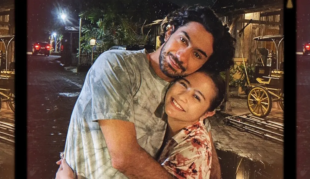 Pose berpelukan, Prilly terlihat mengenakan kemeja bermotif tie-dye merah, sama halnya dengan Reza yang mengenakan kaus tie-dye berwarna abu-abu kehijauan. Foto: Instagram.