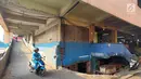 Pengendara motor melintas di pasar tradisional Pasar Mingu di Jakarta, Rabu (17/7). Rencana revitalisasi 21 pasar tradisional di Ibu Kota terancam molor karena status lahan pasar masih dalam proses perubahan sertifikasi. (Liputan6.com/Immanuel Antonius)