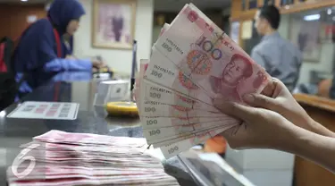 Seorang teller menunjukan  mata uang Yuan di Jakarta, Senin (30/11). Dana Moneter Internasional (IMF), Senin (30/11), resmi memasukan yuan, atau renminbi, ke dalam special drawing rights (SDR) sebagai mata uang elite dunia. (Liputan6.com/Angga Yuniar)