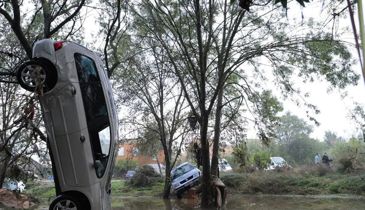 Sebuah mobil tersangkut di pohon usai banjir reda di Grabels, Prancis, Selasa (7/10/2014) (AFP PHOTO/Sylvain THOMAS)