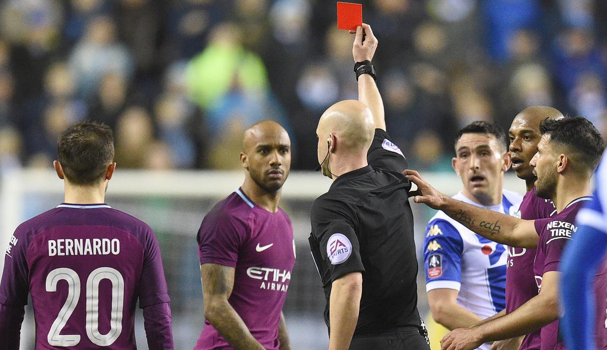 Wasit Anthony Taylor memberikan kartu merah kepada pemain Manchester City. Fabian Delph (2kiri) pada laga babak kelima Piala FA di DW Stadium, Wigan, (19/2/2018). Manchester City kalah 0-1. (AFP/Oli Scarff)
