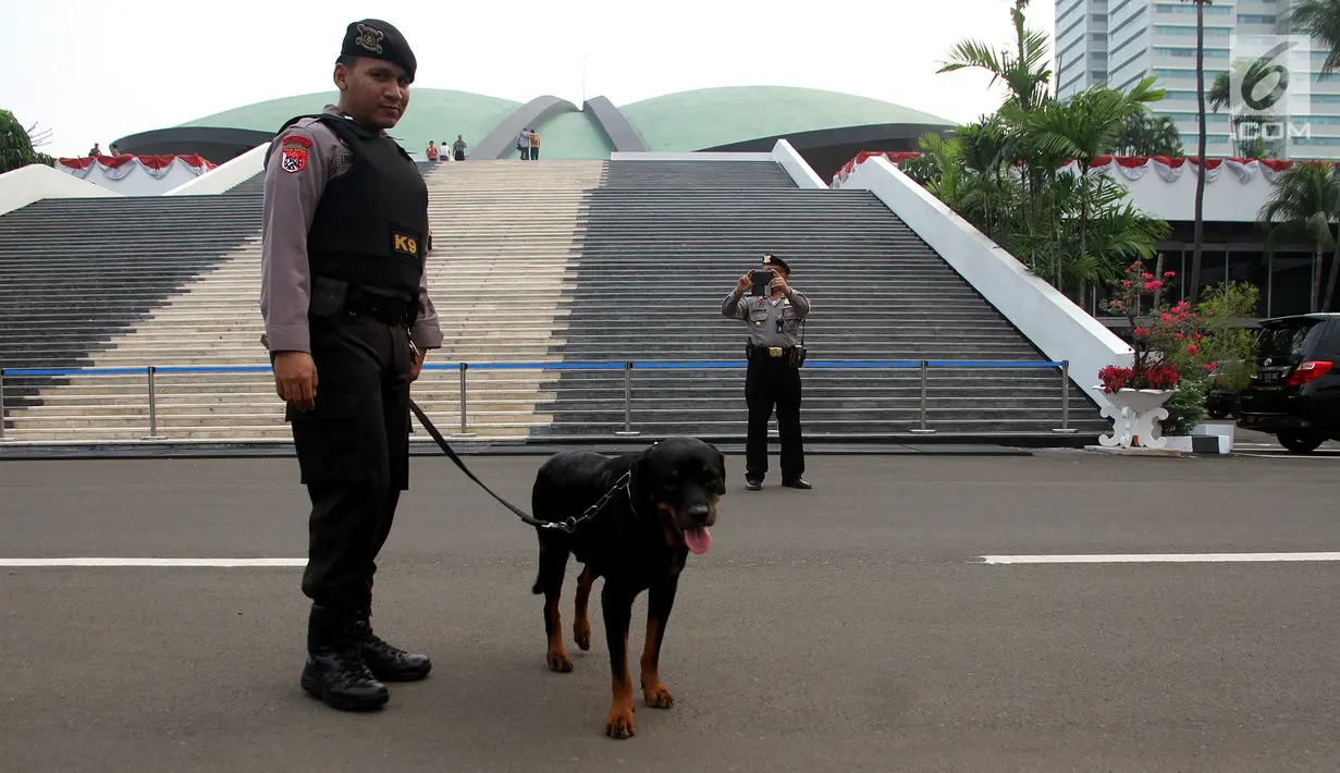 Petugas kepolisian membawa Anjing K-9 untuk berjaga saat persiapan pidato Presiden di Kompleks Parlemen, Senayan, Jakarta, Senin (14/8). Penjagaan tersebut tersebut dilakukan untuk persiapan menjelang Pidato presiden. (Liputan6.com/Johan Tallo)