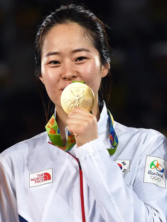 Oh Hye-Ri mencium medali emas yang ia raih di cabang Taekwondo 67kg wanita Olimpiade 2016 di Carioca Arena 3, Rio de Janeiro, Brazil, (19/8). Oh Hye-Ri sukses menyumbang emas kedua Korsel dari cabang taekwondo. (AFP PHOTO/Ed Jones)