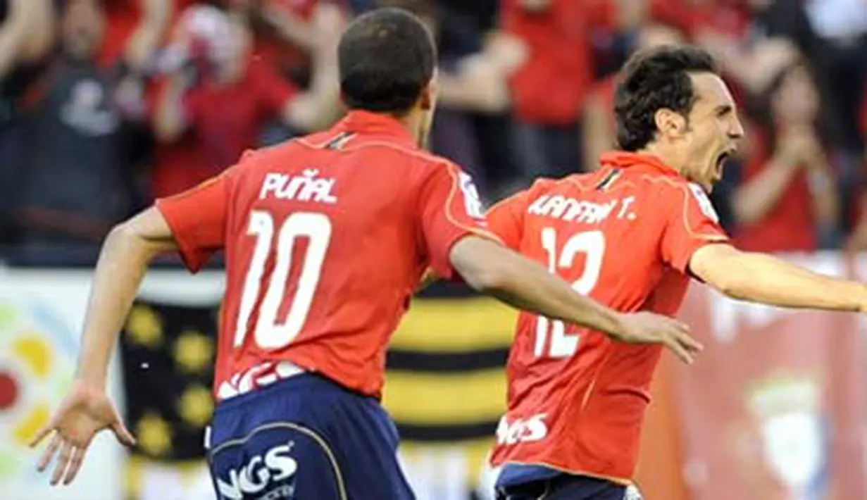 Osasuna's Juanfran (R) celebrates his goal during a Spanish league football match against Real Madrid, on May 31, 2009, at Reyno de Navarra stadium in Pamplona. AFP PHOTO/Rafa Rivas 