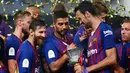 Pemain Barcelona melihat Piala Super Spanyol usai pertandingan melawan Sevilla di Tangier, Maroko, (13/8). Barcelona meraih gelar ke-13 di Piala Super Spanyol terbanyak ketimbang tim lain. (AP Photo/Mosa'ab Elshamy)