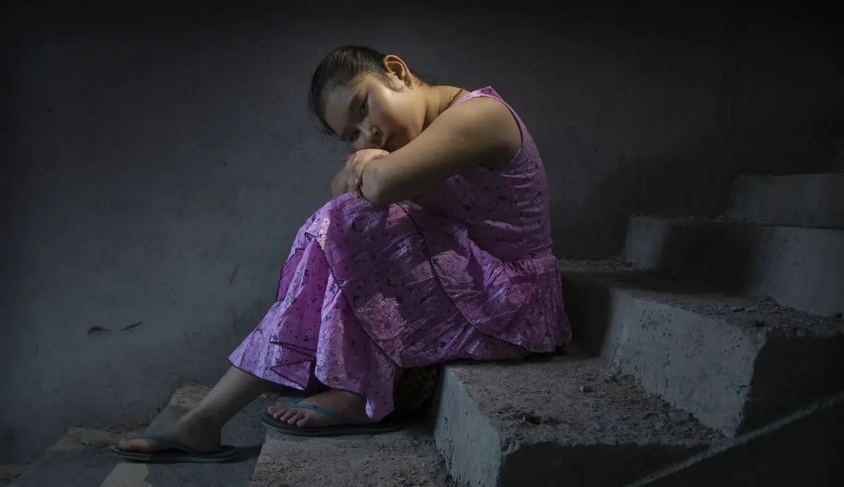 Jeshmi Narzary (10) duduk di tangga rumah bibinya setelah kedua orang tuanya meninggal karena COVID-19, di Kokrajhar, di negara bagian Assam, India, 25 Juni 2021. Jeshmi kini diadopsi oleh saudara perempuan ibunya, Phulmati Narzary Goyaria. (AP Photo Anupam Nath)
