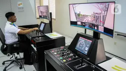 Seorang masinis mengoperasikan simulator kereta Light Rail Vehicle (LRT) Back up Operation Control Centre (BOCC) di Main Control Center (MCC) Depo LRT di Pegangsaan Dua, Kelapa Gading, Jakarta Utara, Kamis (21/12/2023). (Liputan6.com/Faizal Fanani)