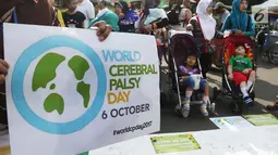 Relawan disabilitas membawa poster Peringatan Hari Cerebral Palsy Sedunia di area Car Free Day, Bundaran HI, Jakarta, Minggu (8/10). Kegiatan itu memperingati Hari Cerebral Palsy Sedunia yang jatuh pada tanggal 6 Oktober. (Liputan6.com/Angga Yuniar)