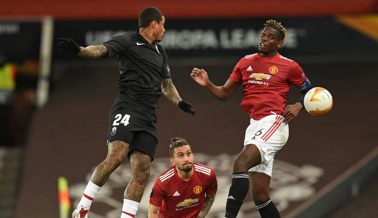 Gelandang Granada, Kenedy (kiri) dan gelandang Manchester United, Paul Pogba berduel udara dalam laga leg kedua perempatfinal Liga Europa 2020/2021 di Old Trafford Stadium, Manchester, Kamis (15/4/2021). Granada kalah 0-2 dari Manchester United. (AFP/Oli Scarff)