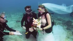 Pendeta John Hauk (kiri) membacakan sumpah pernikahan di bawah laut kepada pasangan Sersan Thomas Mould (tengah) dan Sandra Hyde dari Key Largo, Fla di Florida Keys National Marine Sanctuary (21/12). (Frazier Nivens/Florida Keys News Bureau via AP)