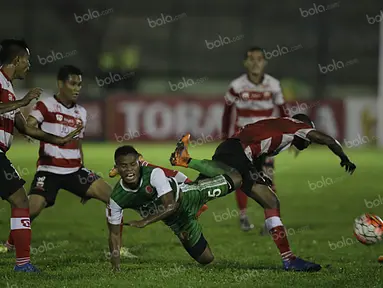 Pemain PS TNI, Manahati Lestusen, berebut bola dengan pemain Madura United, dalam laga Torabika Soccer Championship presented by IM3 Ooredoo di Stadion Siliwangi, Bandung, Minggu (1/5/2016). (Bola.com/Vitalis Yogi Trisna)