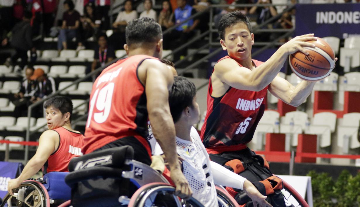 Pebasket Indonesia, Donald Santoso, berusaha melewati pebasket Thailand pada Asian Para Games di Hall Basket, Jakarta, Rabu (10/10/2018). Indonesia kalah 10-62 dari Thailand. (Bola.com/M Iqbal Ichsan)