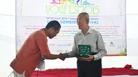 Yudhi Widdyantoro sedang memberikan Yoga Gembira Lifetime Achievement Award kepada Yogamurti 