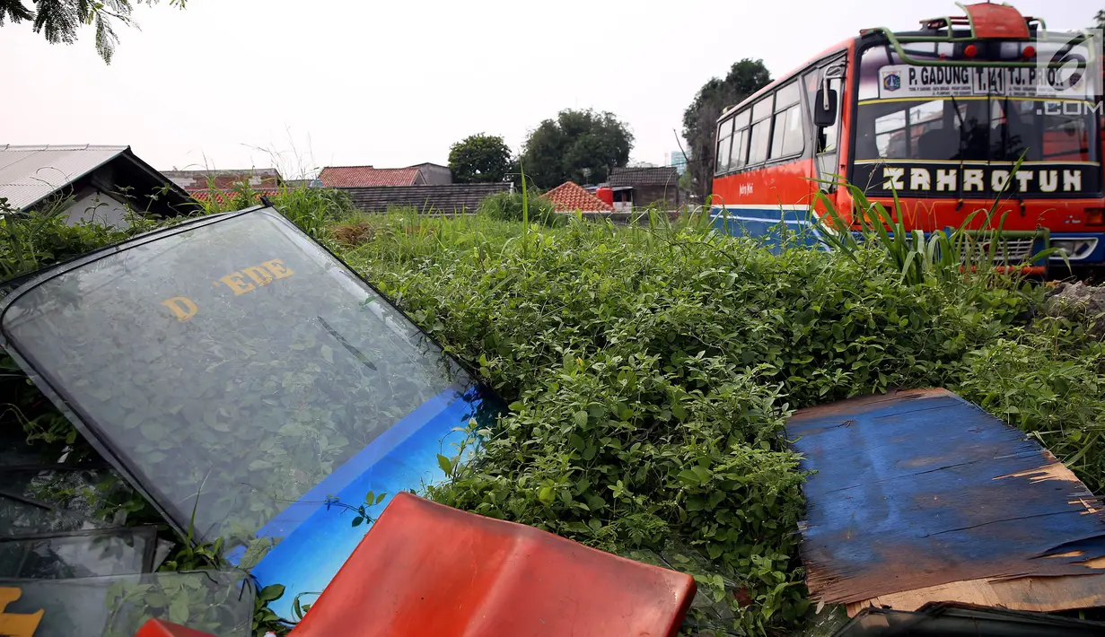 Bagian kaca depan dari Metromini dikumpulkan usai dilepas di salah satu pool Metromini, Jalan Pulogebang, Jakarta, Rabu (3/1). Metromini yang tidak layak jalan dan berusia lebih dari sepuluh tahun akan dikandangkan. (Liputan6.com/JohanTallo)