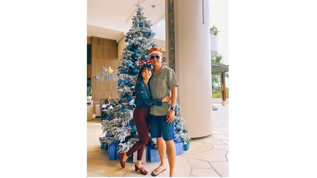 Keduanya terlihat mesra saat befoto dengan background pohon Natal yang bernuansa biru.