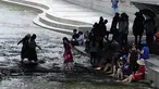 Warga bermain air saat siang hari di Sungai Cheonggye, Seoul, Korea Selatan, Senin (23/7). Korea Selatan tengah dilanda cuaca panas sepanjang pekan ini. (AP Photo/Lee Jin-man)