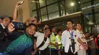 Para fans melakukan swafoto dengan dua tunggal putra Indonesia, Anthony Ginting dan Jonatan Christie saat acara penyambutan para juara All England 2024 di Terminal 3 Bandara Soekarno Hatta, Tangerang, Banten, Senin (18/3/2024) malam WIB. (Bola.com/M Iqbal Ichsan)