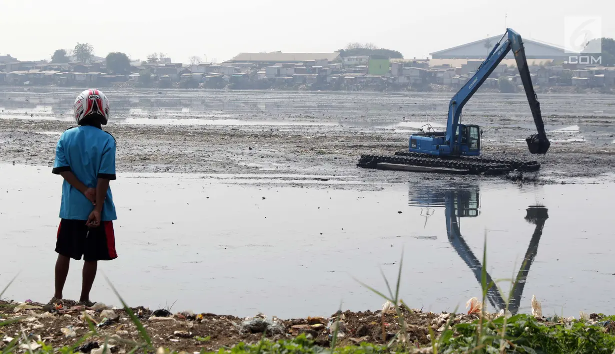 Warga melihat proses pengerukan endapan lumpur di Waduk Pluit, Jakarta, Selasa (11/6/2019). Pengerukan ini untuk mencegah terjadinya pendangkalan permukaan waduk. (Liputan6.com/Helmi Fithriansyah)