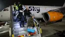 Pengungsi Yahudi Ukraina dan imigran baru yang melarikan diri dari perang di negara mereka turun dari pesawat setibanya di Bandara Ben Gurion, Tel Aviv, Israel, 22 Desember 2022. Sebanyak 100 orang Yahudi Ukraina tiba di Israel, termasuk beberapa penumpang yang terbaring di tempat tidur dan dalam kondisi sakit. (GIL COHEN-MAGEN/AFP)