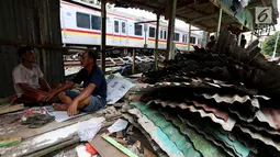 Warga berbincang didekat bongkaran rumah di area Rusun Bendungan Hilir (Benhil) II, Jakarta, Minggu (3/12). Bangunan liar tersebut dibongkar karena berdiri di atas lahan PT Kereta Api Indonesia (PT KAI). (Liputan6.com/JohanTallo)