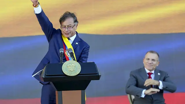 Presiden Kolombia Gustavo Petro mengacungkan tinju pada akhir pidato pelantikannya di Bogota, Kolombia, Minggu, 7 Agustus 2022. (AP Photo/Fernando Vergara)