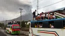 Anak-anak berangkat sekolah a dengan latar belakang Gunung Sinabung yang menyemburkan abu dan asap tebal, sebagaimana terlihat dari Karo, Provinsi Sumatra Utara, Rabu, 2 September 2026. (AFP/ YT Haryono)