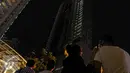 Warga melihat titik api yang masih tersisa di Gedung Neo Soho, Jakarta Barat, Rabu (9/11). Gedung Neo Soho sempat terbakar hebat hampir di setiap lantainya. (Liputan6.com/Faizal Fanani)