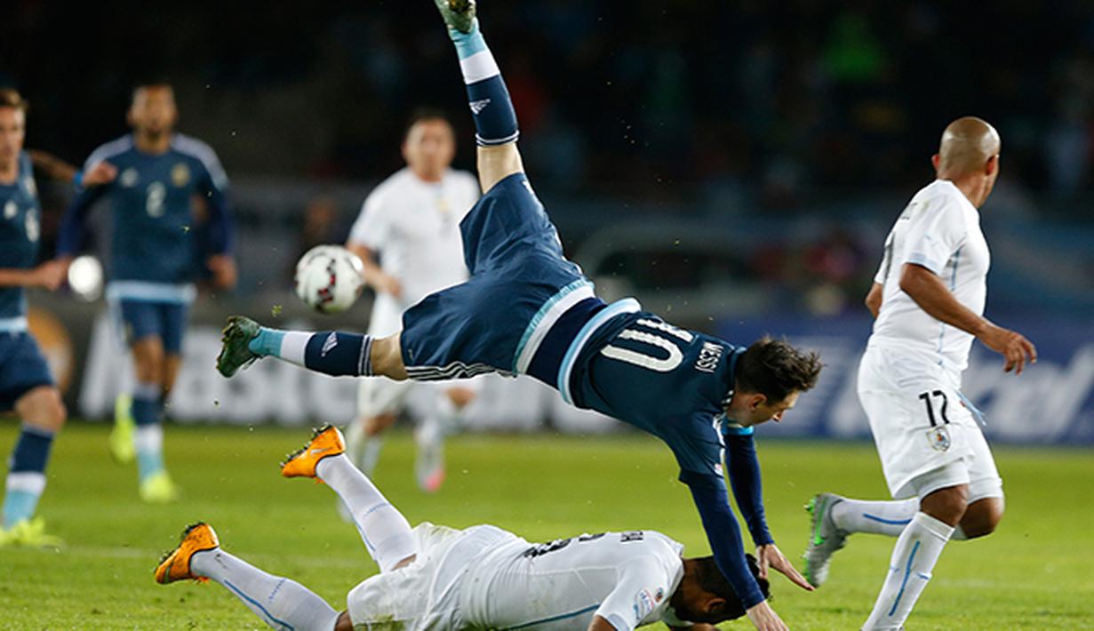 Lionel Messi terjungkal saat berduel dengan bek Uruguay Alvaro Pereira. (AP/Andre Penner)