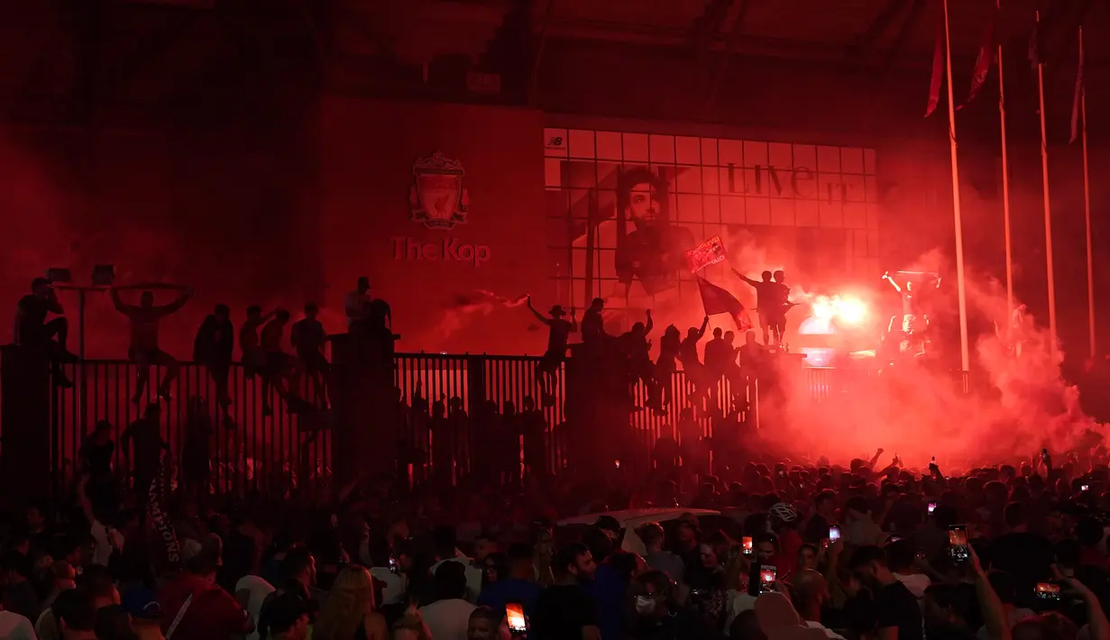 Pendukung Liverpool merayakan gelar juara Liga Premier di luar Stadion Anfield, Kamis (25/6/2020). Trofi juara Liga Primer musim 2019-2020 Trofi juara Liga Primer musim 2019-2020 tersebut dimenangkan Liverpool setelah Manchester City takluk 1-2 dari Chelsea. (AP/Jon Super)