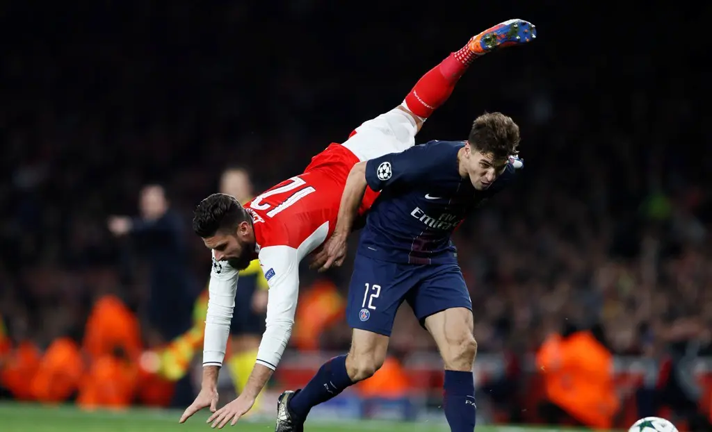 Striker Arsenal, Olivier Giroud, terjungkal saat berebut bola dengan pemain Paris Saint-Germain, Thomas Meunier, pada pertandingan kelima Grup A Liga Champions di Stadion Emirates, Rabu (23/11/2016). (Reuters/Stefan Wermuth)