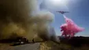 Sebuah kapal tanker menjatuhkan air saat memadamkan api di Cherry Valley, California (1/8/2020). Sebanyak 7.800 warga dievakuasi  akibat kebakaran hutan yang menghanguskan sekitar 4.000 hektar lahan pada akhir pekan kemarin. (AP Photo/Ringo H.W. Chiu)