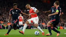 Gelandang Arsenal, Theo Walcott (kedua kiri) berusaha melewati tiga pemain Muenchen pada pertandingan liga Champions di Emirates Stadium, London, Inggris  (20/10/15). Arsenal menang atas Muenchen dengan skor 2-0. (Reuters/Tony O'Brien)