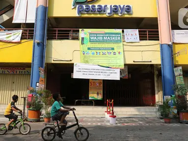 Anak-anak bermain sepeda di area Pasar Tomang Barat, Jakarta, Senin (29/06/2020). Pasar Tomang Barat atau yang lebih dikenal dengan sebutan Pasar Kopro itu ditutup mulai 29 Juni hingga 1 Juli setelah ada pedagang yang dinyatakan positif Covid-19 dari hasil tes usap. (Liputan6.com/Herman Zakharia)