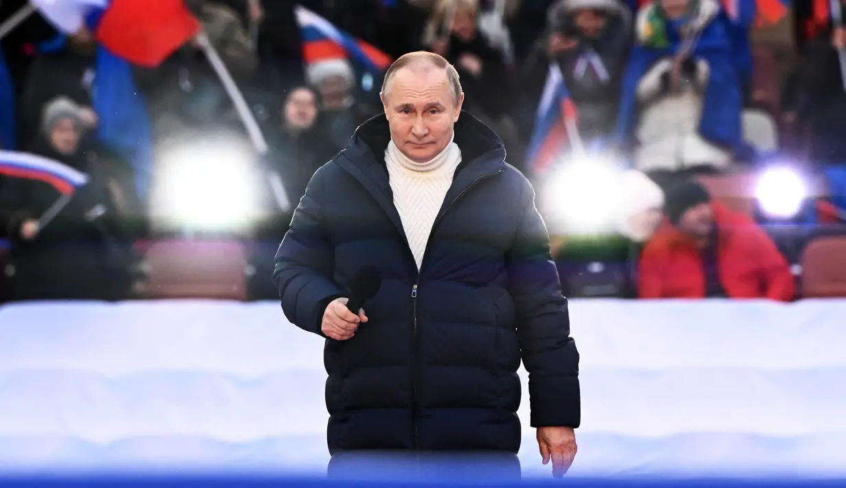 Presiden Rusia Vladimir Putin saat menyampaikan pidatonya pada konser perayaan  delapan tahun referendum tentang status negara bagian Krimea dan Sevastopol serta penyatuannya kembali dengan Rusia, di Moskow, Rusia (18/3/2022). (Sergei Guneyev/Sputnik Pool Photo via AP)